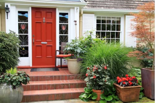Red front door and plants at entrance, replacement doors in Greenville concept
